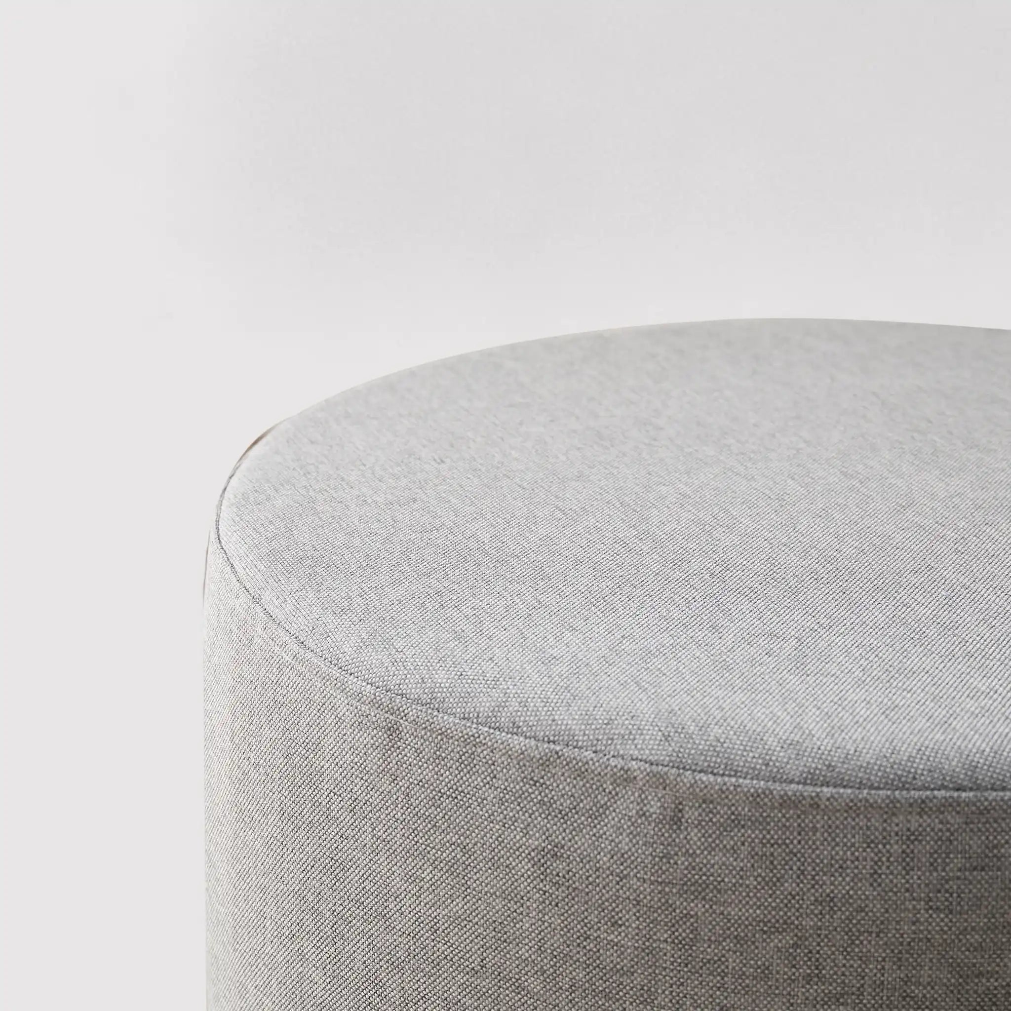 Round gray footrest ottoman in padded fabric